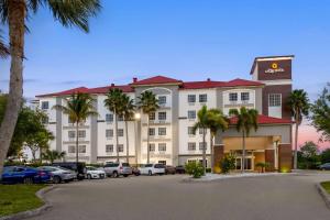 a hotel with palm trees in front of a parking lot at La Quinta by Wyndham Ft. Pierce in Fort Pierce
