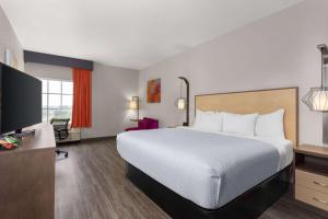 a hotel room with a bed and a flat screen tv at La Quinta by Wyndham Ft. Pierce in Fort Pierce +22 photos