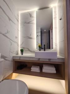 y baño con lavabo blanco y espejo. en Hotel Casa Gardenia, en Barcelona