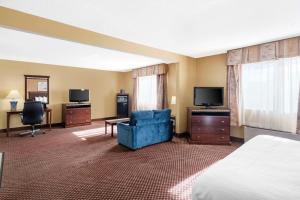 ブルーミントンにあるQuality Inn & Suites Bloomington University Areaのベッドとテレビが備わるホテルルームです。