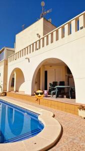 une maison avec une piscine en face de celle-ci dans l'établissement Flamingo Vila Alicante, à San Pedro del Pinatar