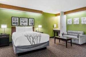 a bedroom with a bed and a desk and a couch at Sleep Inn Sea Tac Airport in SeaTac
