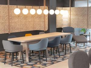 a conference room with a wooden table and chairs at Novotel Blois Centre Val De Loire in Blois