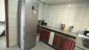 a kitchen with a stainless steel refrigerator and a microwave at LAX'S RELAXING HOME - appartement Bonamoussadi in Deido