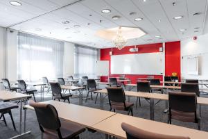 a classroom with tables and chairs and a whiteboard at Scandic Hønefoss in Hønefoss