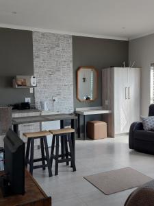 a living room with a kitchen with a counter and stools at Silver Oaks Airbnb in Langebaan