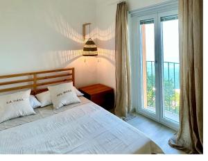 een slaapkamer met een bed en een groot raam bij LA CASA SUL MARE in San Vito Chietino