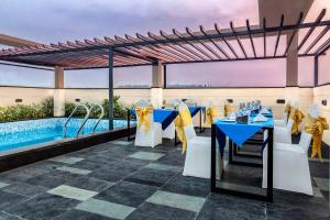 a restaurant with blue tables and chairs and a swimming pool at Hotel Palacio in Guwahati