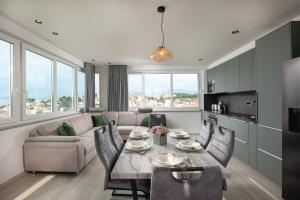 a living room with a table and a couch at Apartman Palma and Luxury Penthouse for a family with swiming pool,parking,terrace,panoramic view at the sea,Podstrana in Podstrana