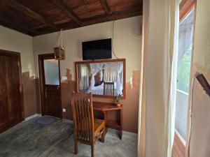 uma sala com um quarto com uma secretária e um espelho em Dorala Villa-Your home away home em Kuruwita