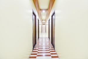 a hallway with a checkerboard floor in a building at FabHotel Royal Empire in Chinchiwad
