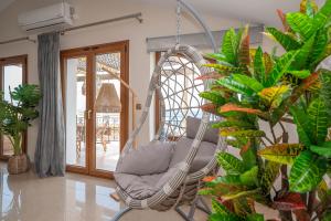 una silla mecedora en una habitación con plantas en Casa di Cuore - Beachfront, en Argassi