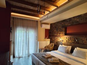 a hotel room with a bed and a stone wall at Ζέον Ύδωρ in Orma