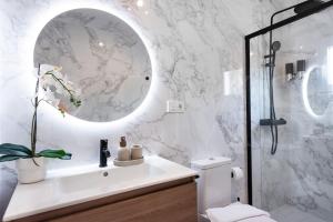 a white bathroom with a sink and a mirror at Apartment with Cathedral view & terrace by REMS in Málaga +51 photos