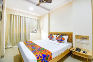 a bedroom with a large bed with a colorful blanket at FabHotel Royal Empire - Bird Valley Udhyan in Chinchiwad
