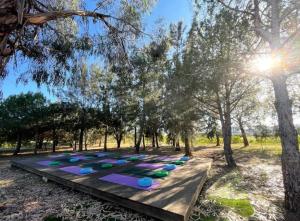 a group of yoga mats on a wooden table in a park at Glamping on Organic Yoga Farm with Natural Swimming Pool near Beach in Moncarapacho