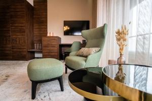 a living room with a chair and a table at Barack Thermal Hotel and Spa in Tiszakécske