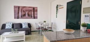 德爾錫倫西奧海岸的住宿－Parque don Jose，厨房以及带沙发和桌子的客厅。