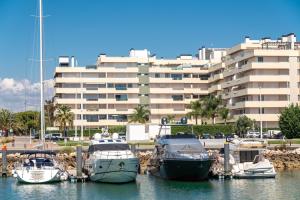 a group of boats docked in a harbor with a building at Marina Vilamoura Aquamar 104 By Vilamoura Sun in Vilamoura