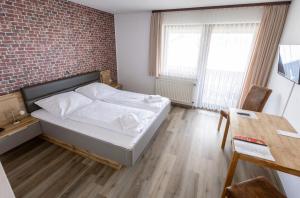 a bedroom with a bed and a brick wall at Hotel-Restaurant Zum Schwalbennest in Alsfeld
