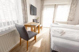 a bedroom with a desk and a bed and a chair at Hotel-Restaurant Zum Schwalbennest in Alsfeld