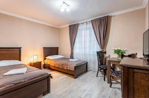 um quarto de hotel com duas camas e uma secretária e uma secretária em Penzion U Císařské cesty em Držovice