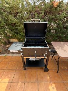 una parrilla de barbacoa en un patio con una mesa en Chalet con piscina privada en Calles en Calles