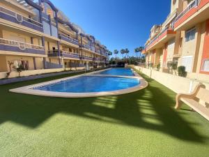 a swimming pool in the courtyard of a building at Delfines II Solo Familias Serviplaya in Playa de Xeraco