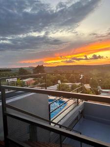 a view of the sunset from the balcony of a building at Mandua in Puerto Iguazú