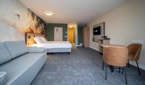 um quarto de hotel com uma cama e um sofá em Fletcher Hotel-Restaurant Langewold em Roden