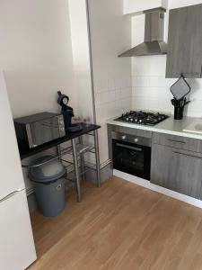 a small kitchen with a stove and a sink at Bel appartement 2 chambres n11 in Moulins