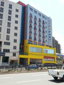 un gran edificio con una fachada amarilla junto a una calle en Wassamar Hotel en Addis Abeba
