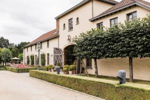 a large building with plants in front of it at Hotel De Barrier in Houthalen-Helchteren
