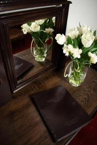 a mirror and a vase of flowers on a table at Hotel Dwór Polski in Wrocław