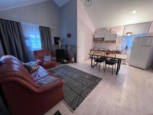 sala de estar con sofá, mesa y cocina en Sunny house near the beach by the bay! en Jūrmala