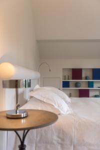 a bedroom with a bed with a table and a lamp at Hotel De Barrier in Houthalen-Helchteren