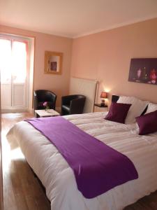 Un pat sau paturi într-o cameră la Hotel Le Beauregard