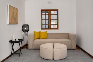 un soggiorno con divano e sgabello di Agapanthus 8 a Città del Capo