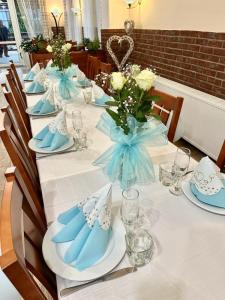uma mesa longa com pratos e flores azuis e brancos em Penzion U Císařské cesty em Držovice