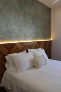 a bedroom with a bed with white pillows at Alieira's House - Pet Friendly in Torres Novas