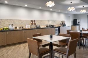Fairfield by Marriott Inn & Suites Fresno Riverpark في فريسنو: مطعم بطاولة وكراسي ومطبخ