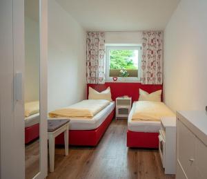 Habitación pequeña con 2 camas y ventana en Haus Am Mühlbach - SommerBergBahn unlimited kostenlos, en Oberstdorf