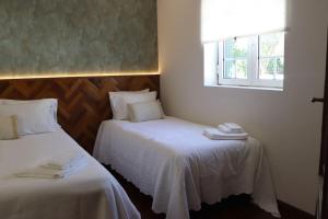 a hotel room with two beds and a window at Alieira's House - Pet Friendly in Torres Novas