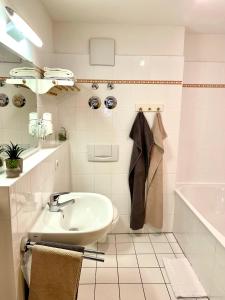 ein Badezimmer mit einem Waschbecken und einer Badewanne in der Unterkunft Haus Am Mühlbach - SommerBergBahn unlimited kostenlos in Oberstdorf