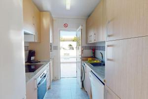 ロス・アルカサレスにあるCasa 1227の白いキャビネット付きのキッチン、パティオへのドア