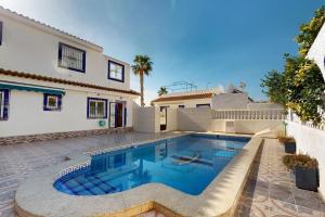 a swimming pool in front of a house at Casa 1227 in Los Alcázares