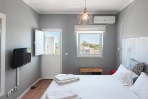 1 dormitorio con 1 cama, TV y ventana en Lagos Uptown Bed & Breakfast, en Lagos