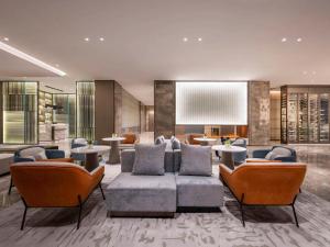 a lobby with a couch and chairs and tables at Novotel Kunshan Yangcheng Lake in Kunshan