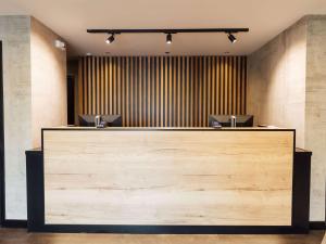 a lobby with a large wooden counter with two desks at ibis Coleraine Riverside in Coleraine