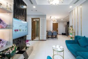 VINHOMES LANDMARK CONDOTEL SUITE في مدينة هوشي منه: غرفة معيشة مع أريكة زرقاء وتلفزيون